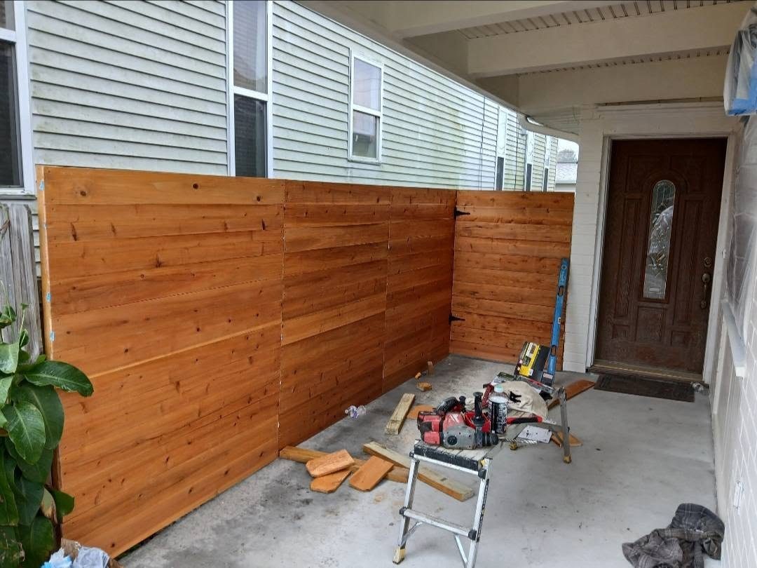 Horizontal cedar privacy fence and gate built beside a covered entry